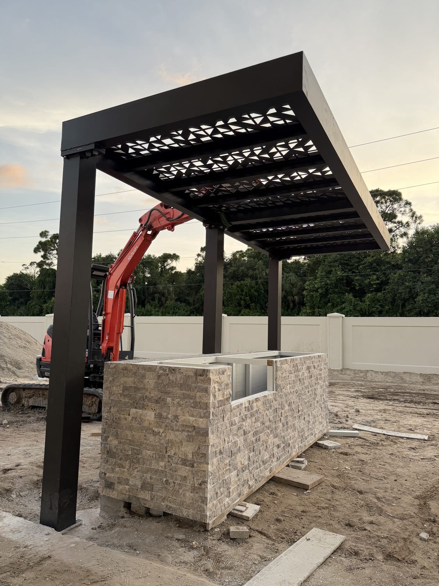 Custom fabricated metal pergola built by Naples Welding Inc. over an outdoor kitchen in Naples, FL